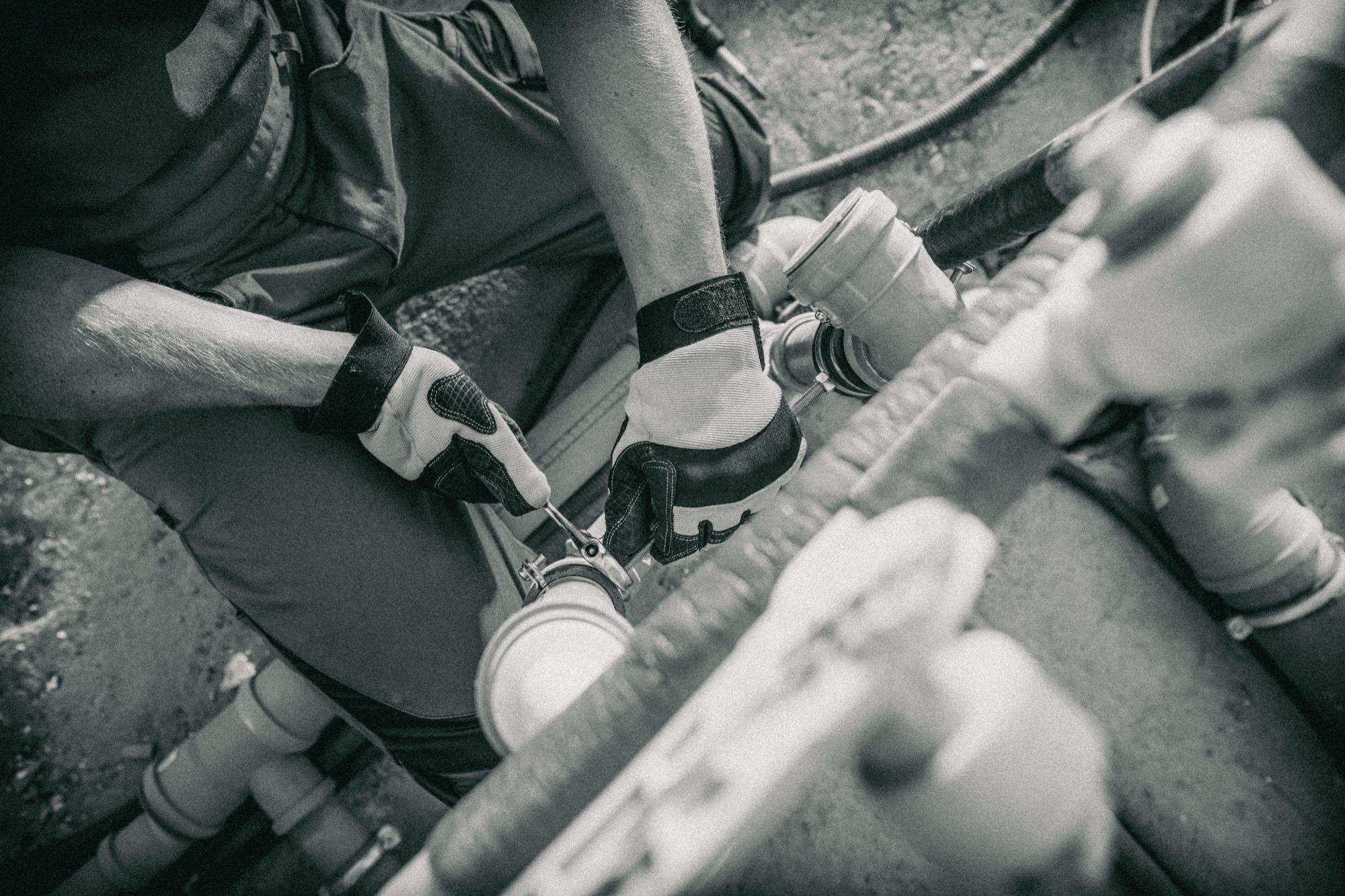 A plumber tightening a pipe fitting