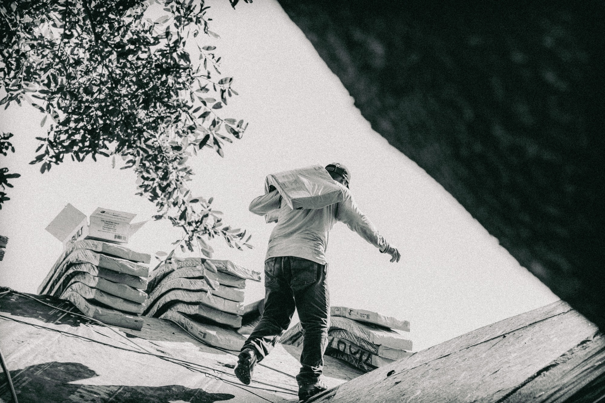 A roofer carrying materials across a roof